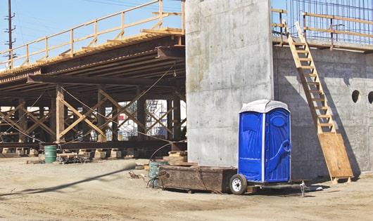 multiple portable restrooms arranged at a busy construction site